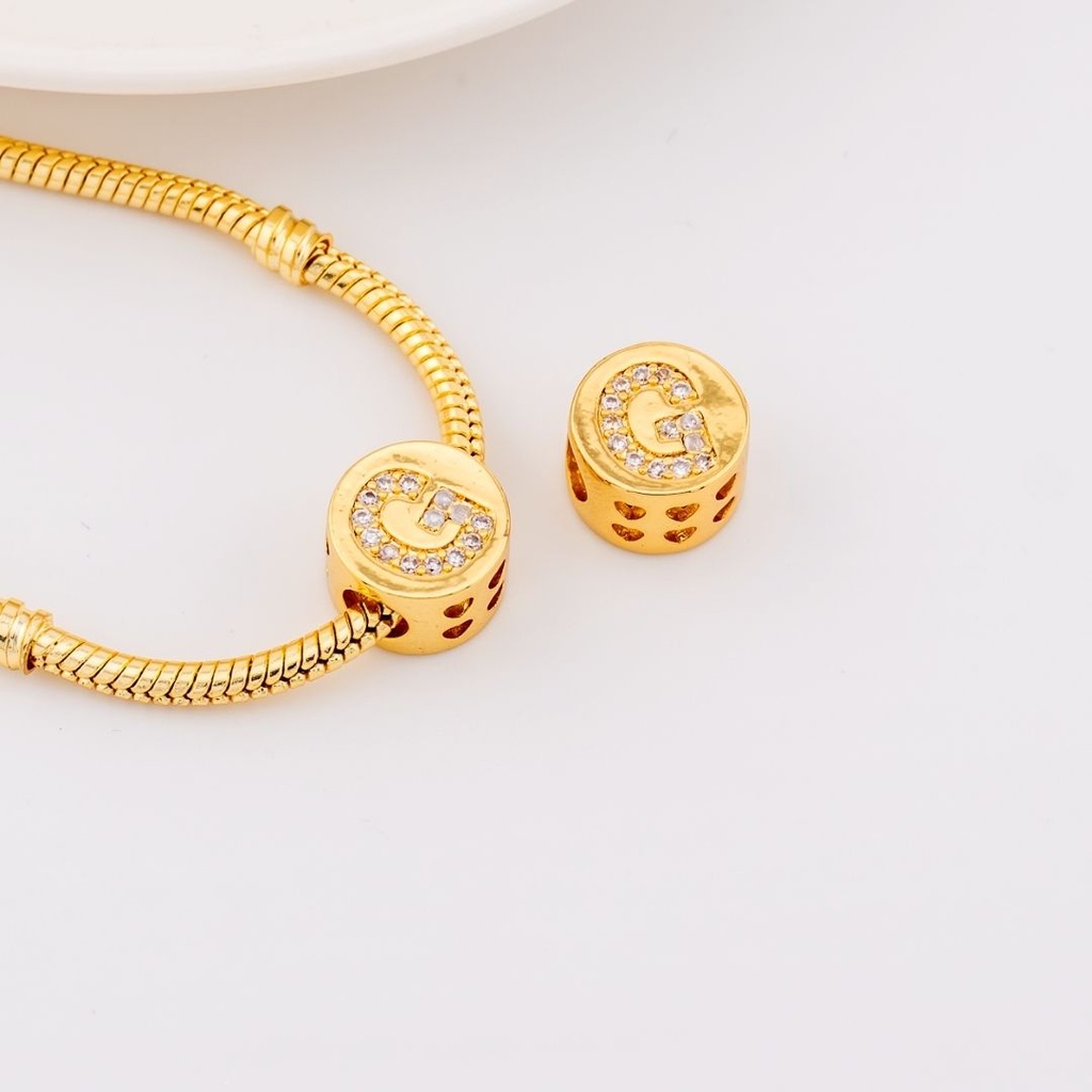 Dije charm estilo pandora con letras en micropave baño de 18k letra G