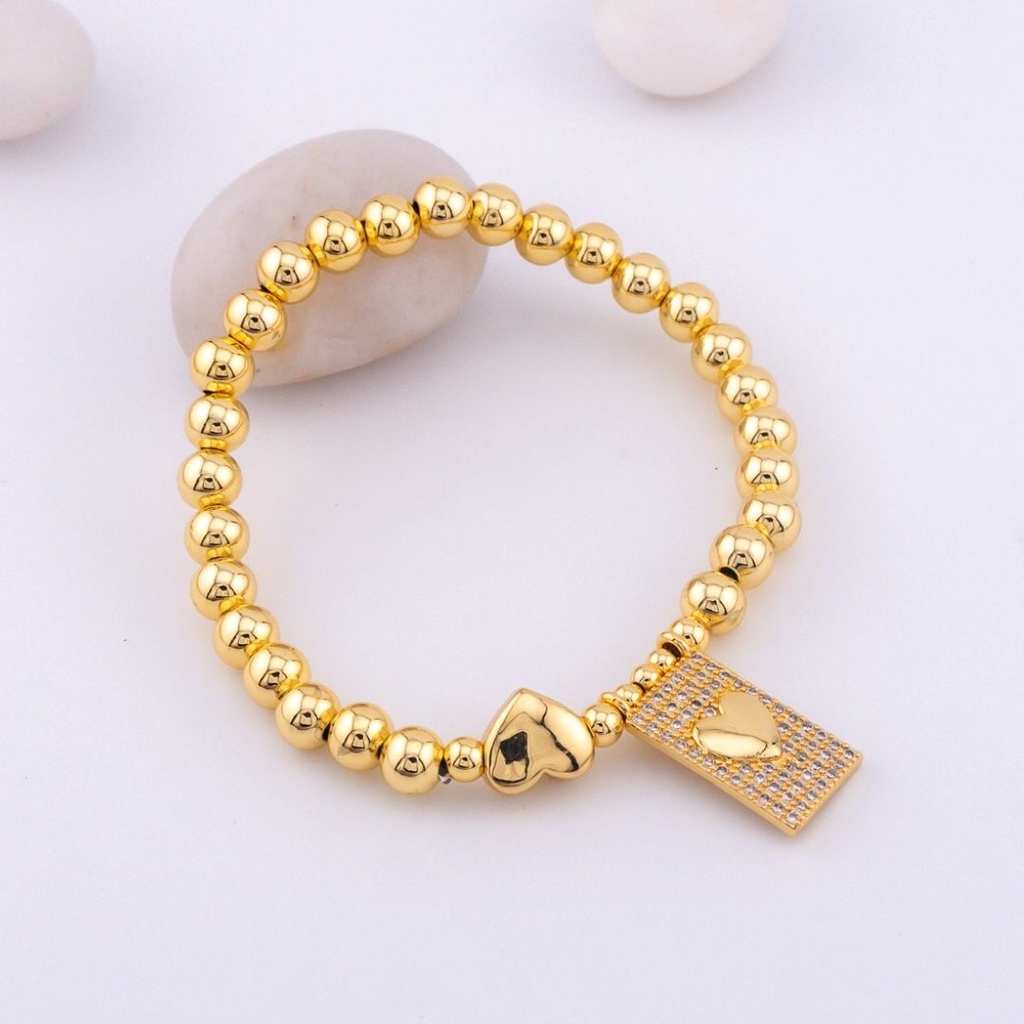 Elegante pulsera elastica con colgante de corazon y bolitas en baño 18k