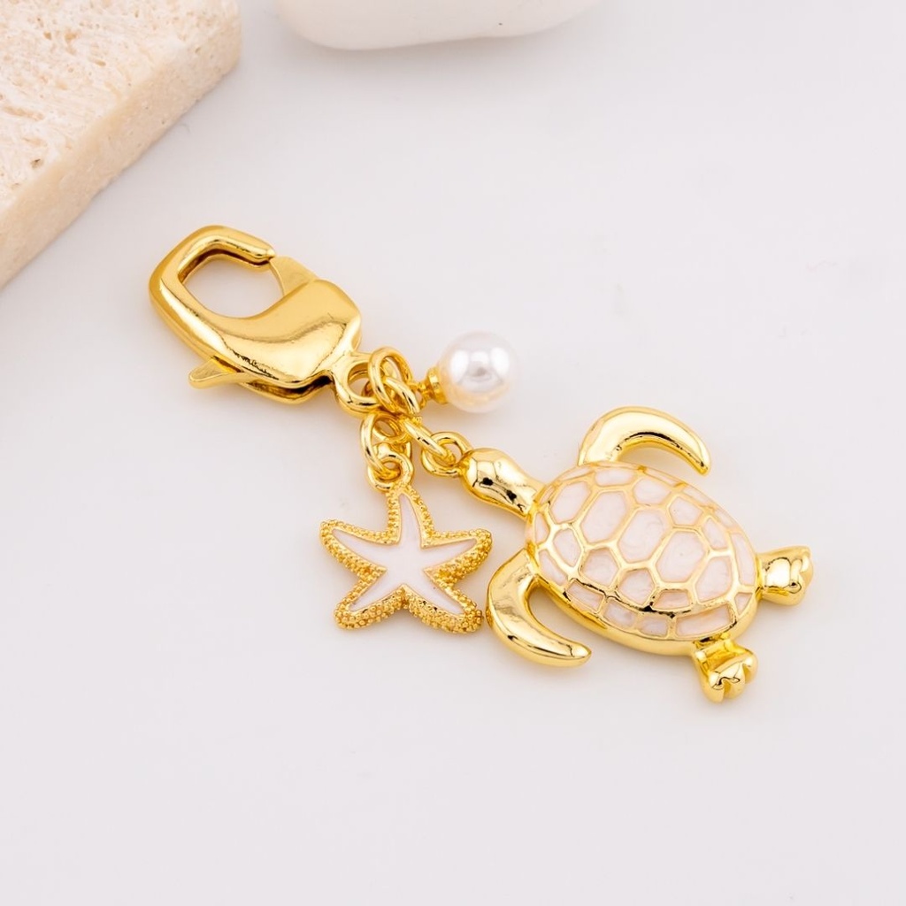 Llavero con dijes tortuga y estrella marina baño 18k