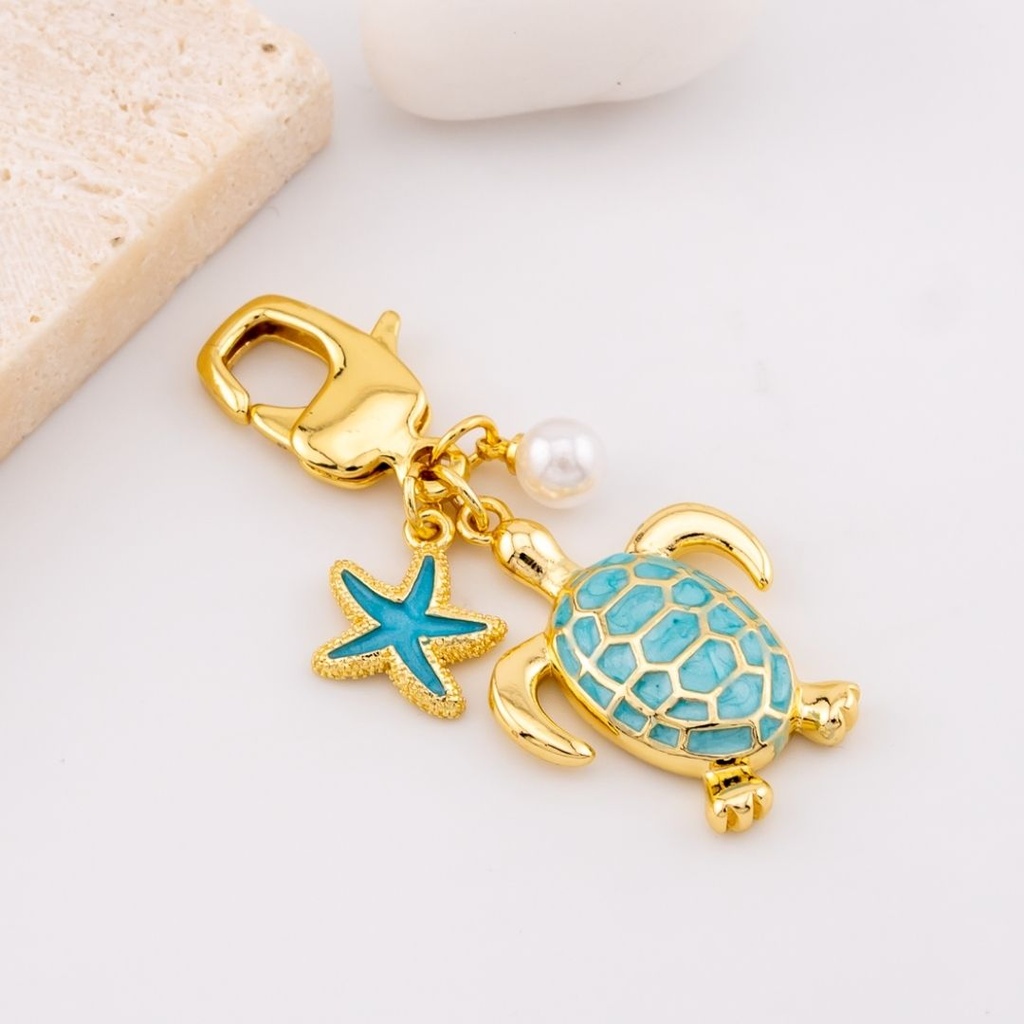 Llavero con dijes tortuga y estrella marina baño 18k