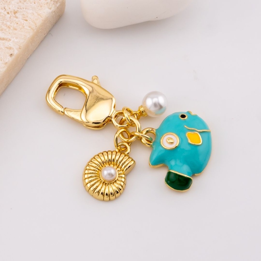llavero con dijes pez y caracol de mar baño 18k
