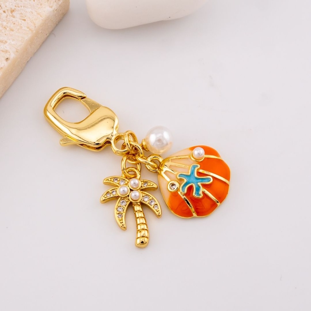 llavero con dijes  palmera y concha de mar micropave y baño 18k
