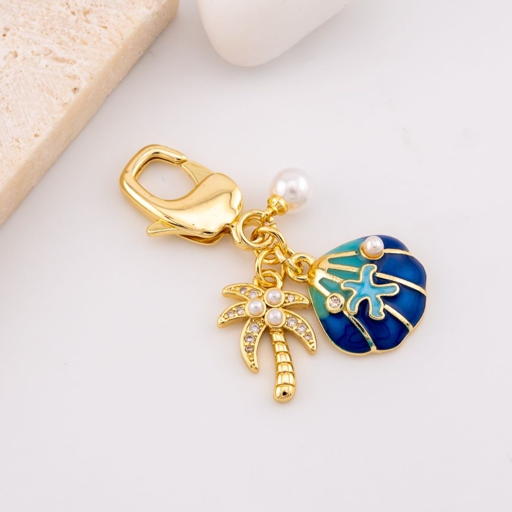 llavero con dijes  palmera y concha de mar micropave y baño 18k