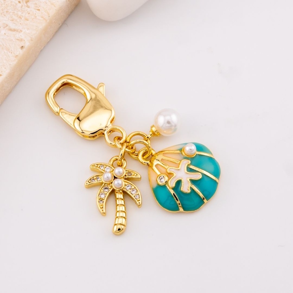 llavero con dijes  palmera y concha de mar micropave y baño 18k