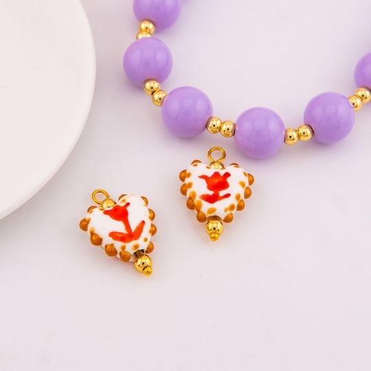 Dije de ceramica vitrificado en forma de corazon con diseño de tulipan baño 18k