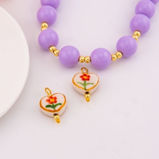 Dije de ceramica vitrificado en forma de corazon con diseño de flor baño 18k
