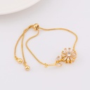 pulsera ajustable con flor giratoria baño 18k
