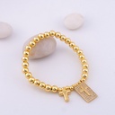 Elegante pulsera elastica con colgante de cruz y bolitas en baño 18k